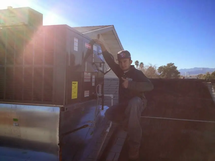 HVAC technician performing AC Tune-Up on a rooftop unit in Fort Gratiot